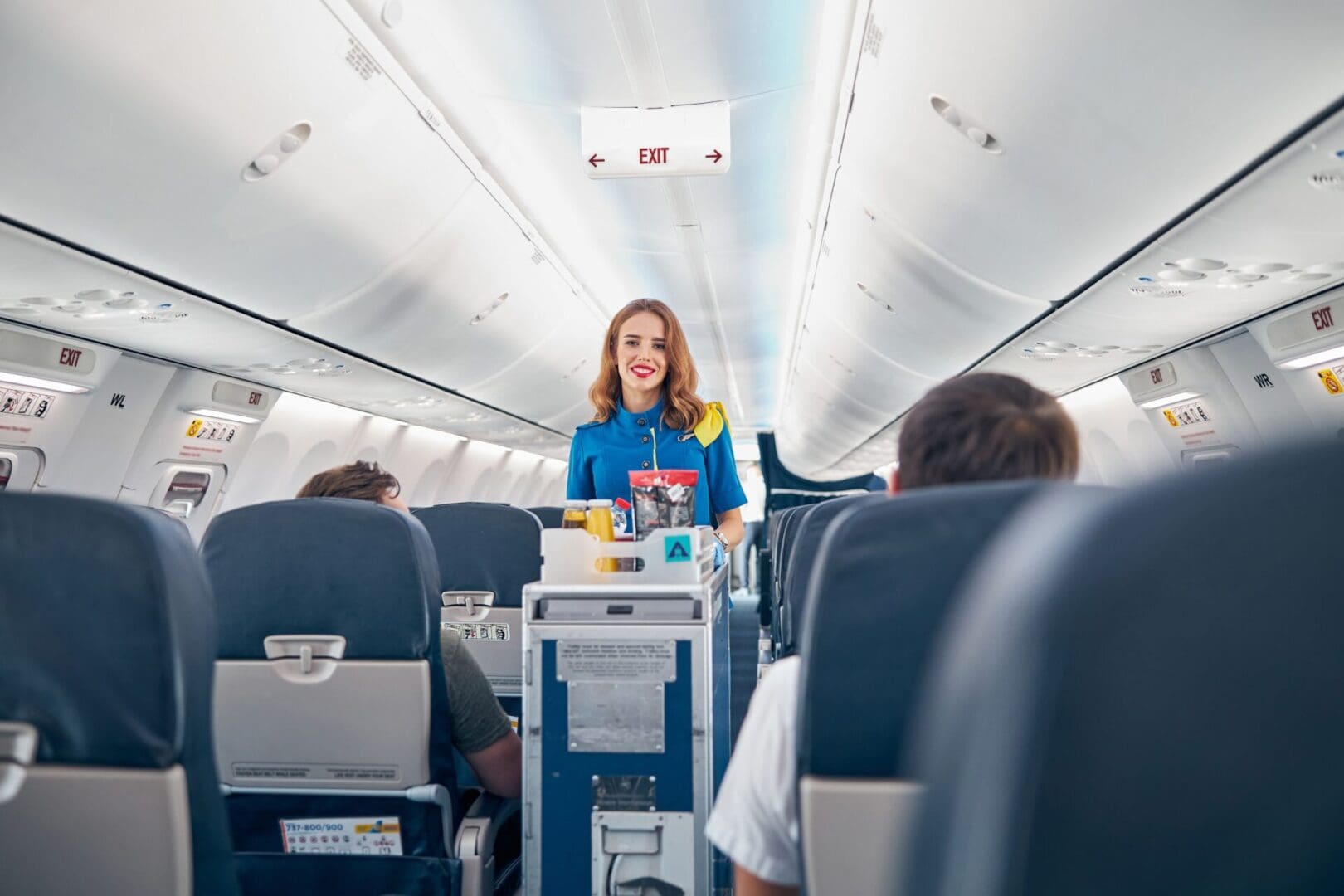 A woman standing on an airplane with other people.