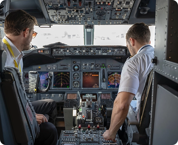 Two pilots are in the cockpit of an airplane.